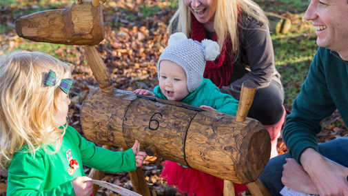 A family gathered around a wooden reindeer